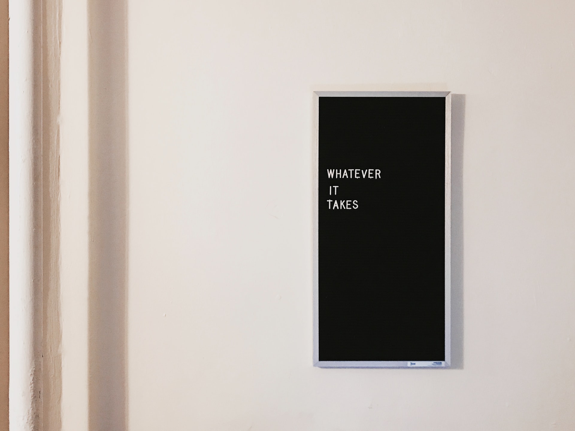 Ein Bild mit der Aufschrift "Whatever it takes" hängt an einer Wand