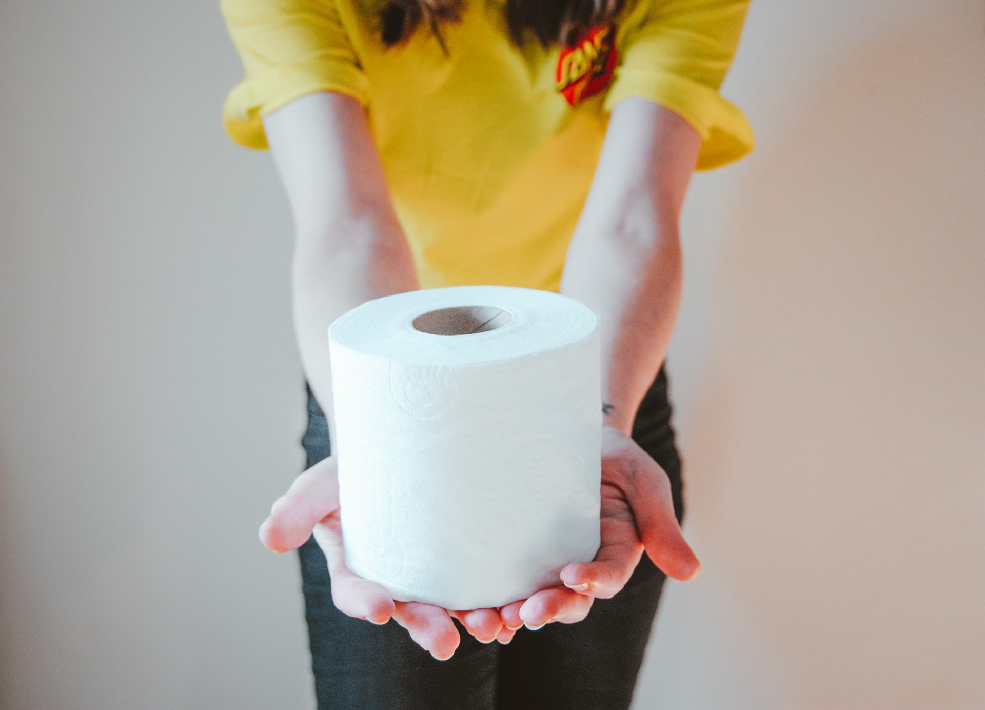 Eine Frau hält eine Rolle Toilettenpapier